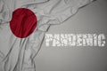 waving colorful national flag of japan on a gray background with broken text pandemic. concept