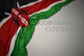 waving national flag of kenya on a gray background with text coronavirus covid-19 . concept Royalty Free Stock Photo