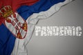 waving colorful national flag of serbia on a gray background with broken text pandemic. concept Royalty Free Stock Photo