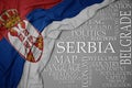 Waving colorful national flag of serbia on a gray background with important words about country Royalty Free Stock Photo