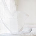 Waving curtain on window in white bedroom Royalty Free Stock Photo