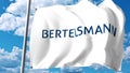 Waving flag with Bertelsmann logo against clouds and sky. Editorial 3D rendering