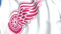 Waving flag with Detroit Red Wings NHL hockey team logo, close-up. Editorial 3D rendering