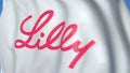 Flying flag with Eli Lilly And Company logo, close-up. Editorial 3D rendering