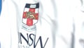 Waving flag with University of New South Wales emblem, close-up. Editorial 3D rendering