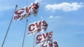 Waving flags with Cvs Pharmacy logo against sky, editorial 3D rendering Royalty Free Stock Photo