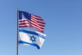 Waving Flags Of USA And Israel On The Same Flagpole On Background Of Blue Sky. Copy Space Royalty Free Stock Photo