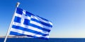 Waving Greek flag against blue sky and the coastline of the island Royalty Free Stock Photo