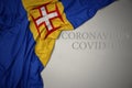 waving national flag of madeira on a gray background with text coronavirus covid-19 . concept