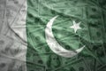 waving pakistani flag on a american dollar money background
