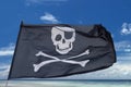 Waving pirate flag jolly roger on tropical island background