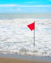 Waving red flag at seashore Royalty Free Stock Photo