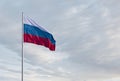 Waving Russian flag against a blue sky with clouds and empty space for text. Room for text.