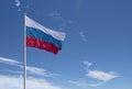 Waving Russian flag against a blue sky with clouds and empty space for text. Room for text.