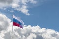 Waving Russian flag against a blue sky with clouds and empty space for text. Room for text. Abstract collage. Royalty Free Stock Photo