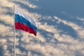 Waving Russian flag against a blue sky with clouds and empty space for text. Room for text. National flag of the Russian Royalty Free Stock Photo