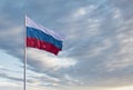 Waving Russian flag against a blue sky with clouds and empty space for text. Room for text. Royalty Free Stock Photo