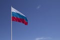 Waving Russian flag against a blue sky with clouds and empty space for text. Room for text. Royalty Free Stock Photo