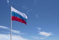 Waving Russian flag against a blue sky with clouds and empty space for text. Room for text.