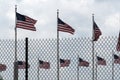 Waving usa flags behind fence grid Royalty Free Stock Photo