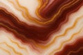 Wavy abstract pattern in red, cream, and golden tones resembling agate texture, featuring smooth transitions and vibrant visual Royalty Free Stock Photo