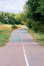 Wavy and bumpy asphalt road. Ahead is a long road that curves undulatingly into the distance with white lines Royalty Free Stock Photo