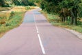 Wavy and bumpy asphalt road. Ahead is a long road that curves undulatingly into the distance with white lines Royalty Free Stock Photo