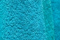 Wavy dry bath towels of color aquamarine hanging in bathroom Royalty Free Stock Photo