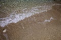 Wavy foamy crystal clear ocean water washing up on sandy beach shore. White waves on sand. Relaxing time. Summer vacations. Leisur Royalty Free Stock Photo