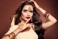 Wavy hair. Portrait of beautiful woman with indian jewelry. Young brunette model with Traditional Indian golden bijouterie set. Royalty Free Stock Photo