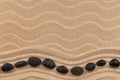 Wavy line made of black stones lying on the sand of a beach. Top view Royalty Free Stock Photo