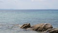 Wavy ocean hitting the rocks and gleaming under the blue sky Royalty Free Stock Photo