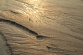 Wavy pattern on wet sandy beach. Royalty Free Stock Photo