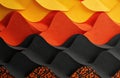 Wavy pattern of yellow orange and black paper creates abstract background texture. Geometric layered design resembles textile or Royalty Free Stock Photo