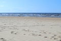 Wavy sand with footsteps on baltic sea coast with wave