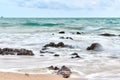 Wavy sea with rocks near a beach Royalty Free Stock Photo