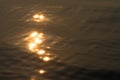 Wavy water surface with glittering orange sun light. 1