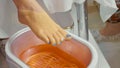 Wax bath for feet at beauty spa salon, close-up.