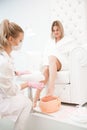Wax bath for feet at beauty spa salon. Paraffin wax treatments for feet. Royalty Free Stock Photo