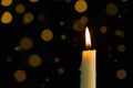 Wax candle burning against blurred lights in darkness, closeup. Space for text Royalty Free Stock Photo