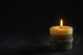 A wax candle is burning on a dark background. Flame of one candle at night close-up. Royalty Free Stock Photo