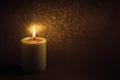 A wax candle is burning on a dark background. Flame of one candle at night close-up. Royalty Free Stock Photo