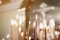 wax candles in the temple next to the cross, the front and back backgrounds are blurred with a bokeh effect