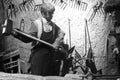 Wax figure of ancient blacksmith hit iron, black and white image