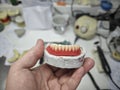 Wax frame of a removable denture and in the hands of a doctor