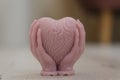 wax sculpture of hands holding a heart pour out of wax candle beautiful home decor close up heart formed with hands and Royalty Free Stock Photo