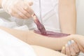Waxing cosmetic depilation procedure warm wax applied to the skin with wooden stick