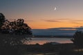 Waxing crescent moon over the sea at Sandwich bay during the golden hour sunset Royalty Free Stock Photo