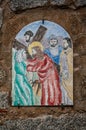 Way of the cross. 5th Station. Simon of Cyrene helps Jesus to carry the cross. Painted ceramic tile, Ingurtosu, Arbus, Sardinia