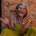 Laughing old nepalese woman with her back agaist an earthen wall Royalty Free Stock Photo